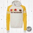 KC Tis the Season varsity hoodie from The Graphic Tee, featuring festive holiday graphic and comfortable sweatshirt style.