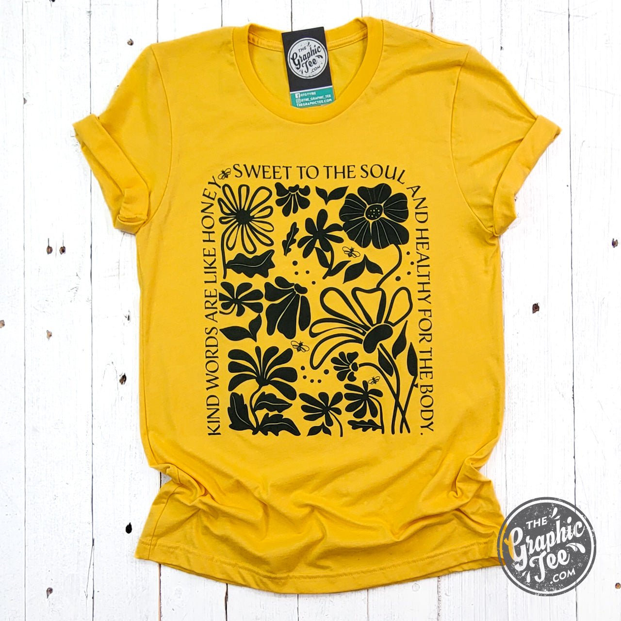 Heather golden yellow short sleeve graphic tee from The Graphic Tee with a "Kind Words" design on the front.