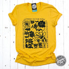 Heather golden yellow short sleeve graphic tee from The Graphic Tee with a "Kind Words" design on the front.