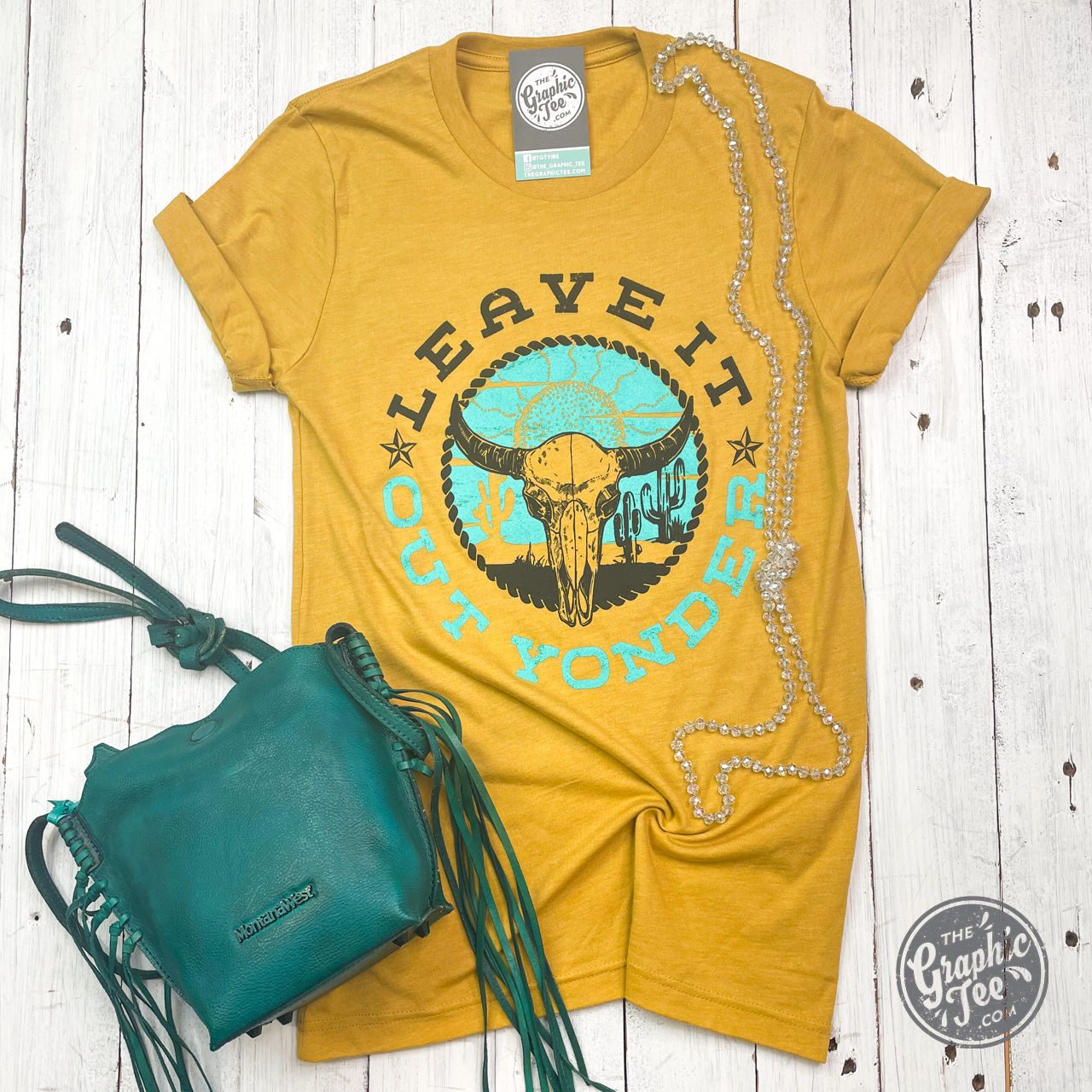 Mustard short sleeve graphic tee by The Graphic Tee with "Leave It Out Yonder" design on front.