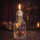 Persephone oil candle by Logos Candles featuring a sleek glass container and a lit wick, ideal for ambient lighting and decoration.