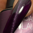 Madam Glam Hocus Plum nail polish bottle with purple and plum shades on a white background.