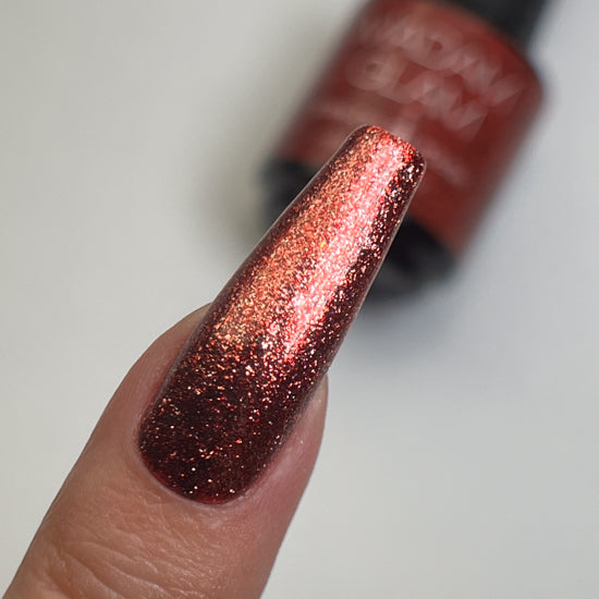 Bright scarlet red nail polish by Madam Glam showcasing a glossy, vibrant color in a sleek bottle.
