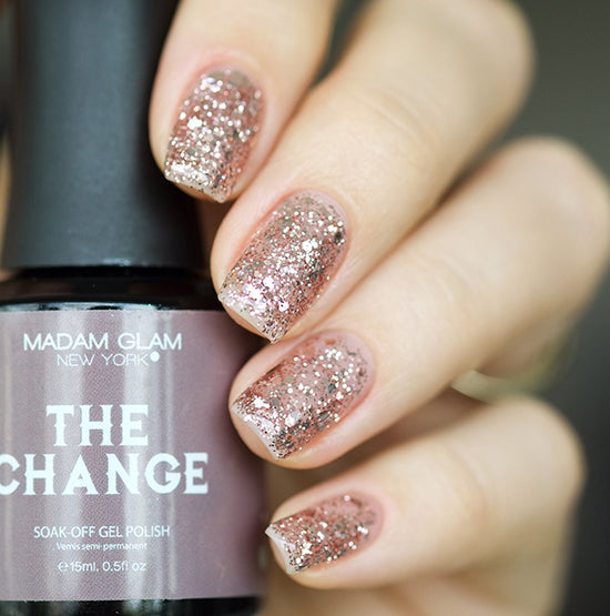 Madam Glam nail polish bottle named The Change with sleek black and gold packaging and a clear label.
