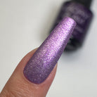 Madam Glam Twilight Tints nail polish bottle with a vibrant purple and blue gradient label on a white background.