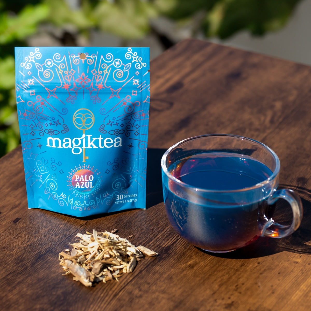 Loose Palo Azul tea from Magiktea in a 5 oz package, USDA Organic, shown in a clear container with dried blue bark pieces.
