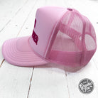 Embroidered trucker cap featuring main character design by The Graphic Tee, with mesh back and adjustable strap.