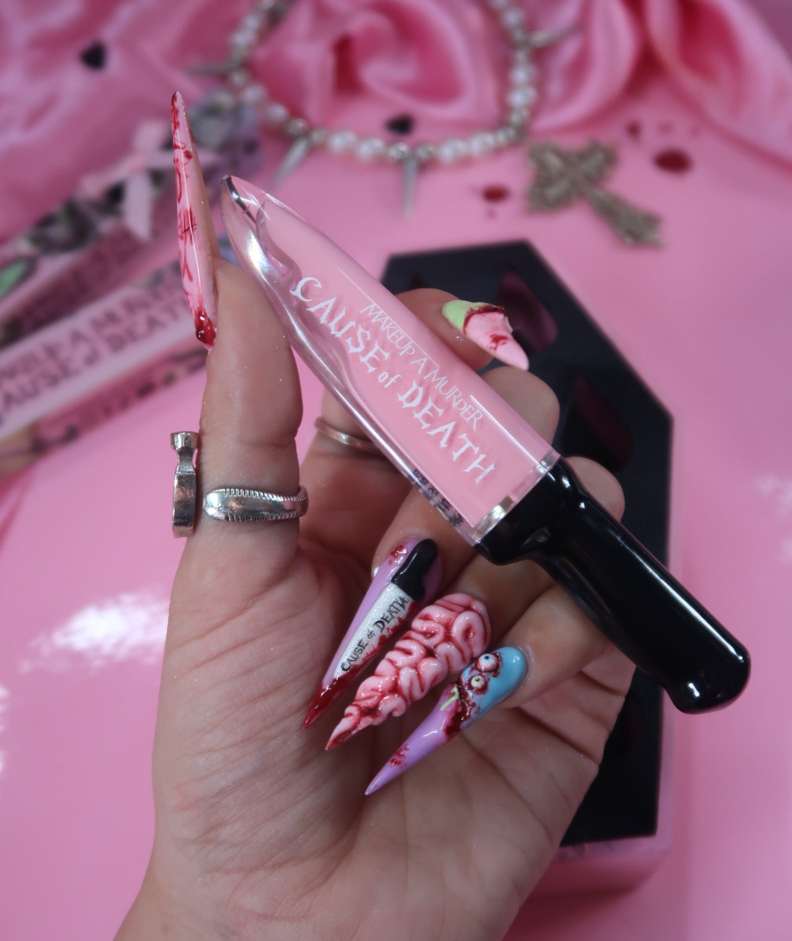 Makeup A Murder, INC Cause of Death Pastel Collection with pastel eyeshadows and makeup products displayed in the image.