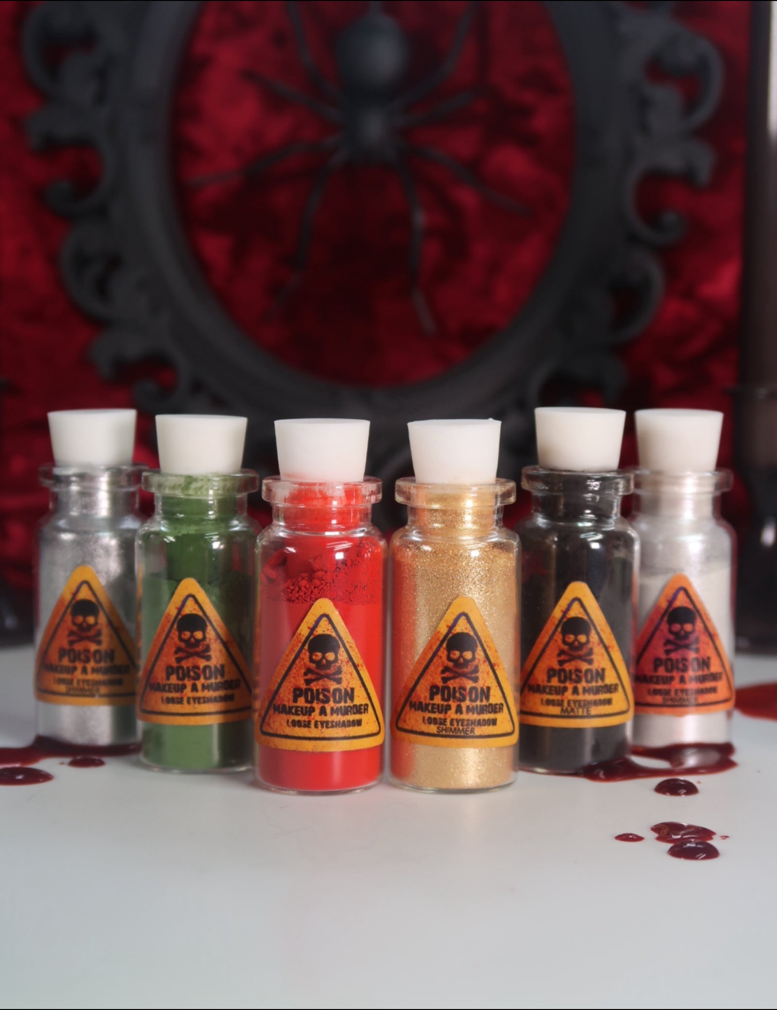 Makeup A Murder, INC Holiday Poison Pigment Collection with vibrant, colorful eyeshadows in festive packaging.