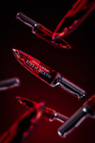KISS of DEATH Bloody Lip Oils full collection by Makeup A Murder, INC featuring vibrant, blood-red lip oil tubes arranged together.