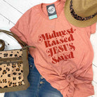 Unisex graphic T-shirt from The Graphic Tee featuring Midwest Raised and Jesus Saved design, casual apparel for men and women.