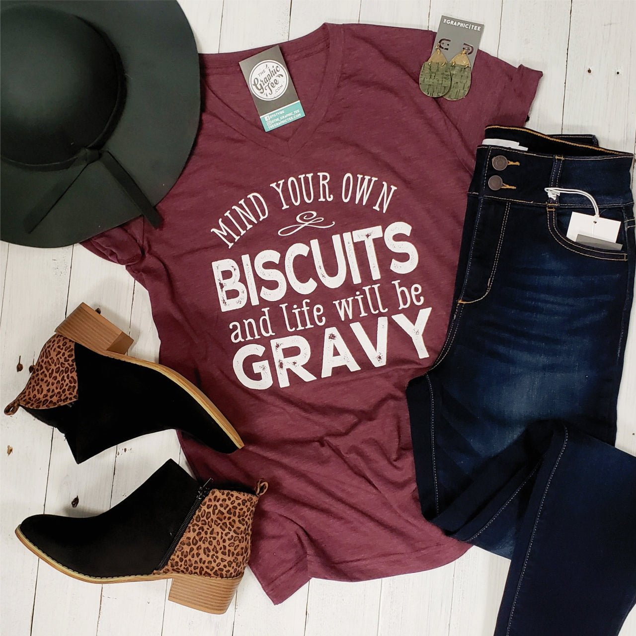 V-Neck Tee from The Graphic Tee featuring a playful "Mind Your Own Biscuits" graphic design on soft fabric.