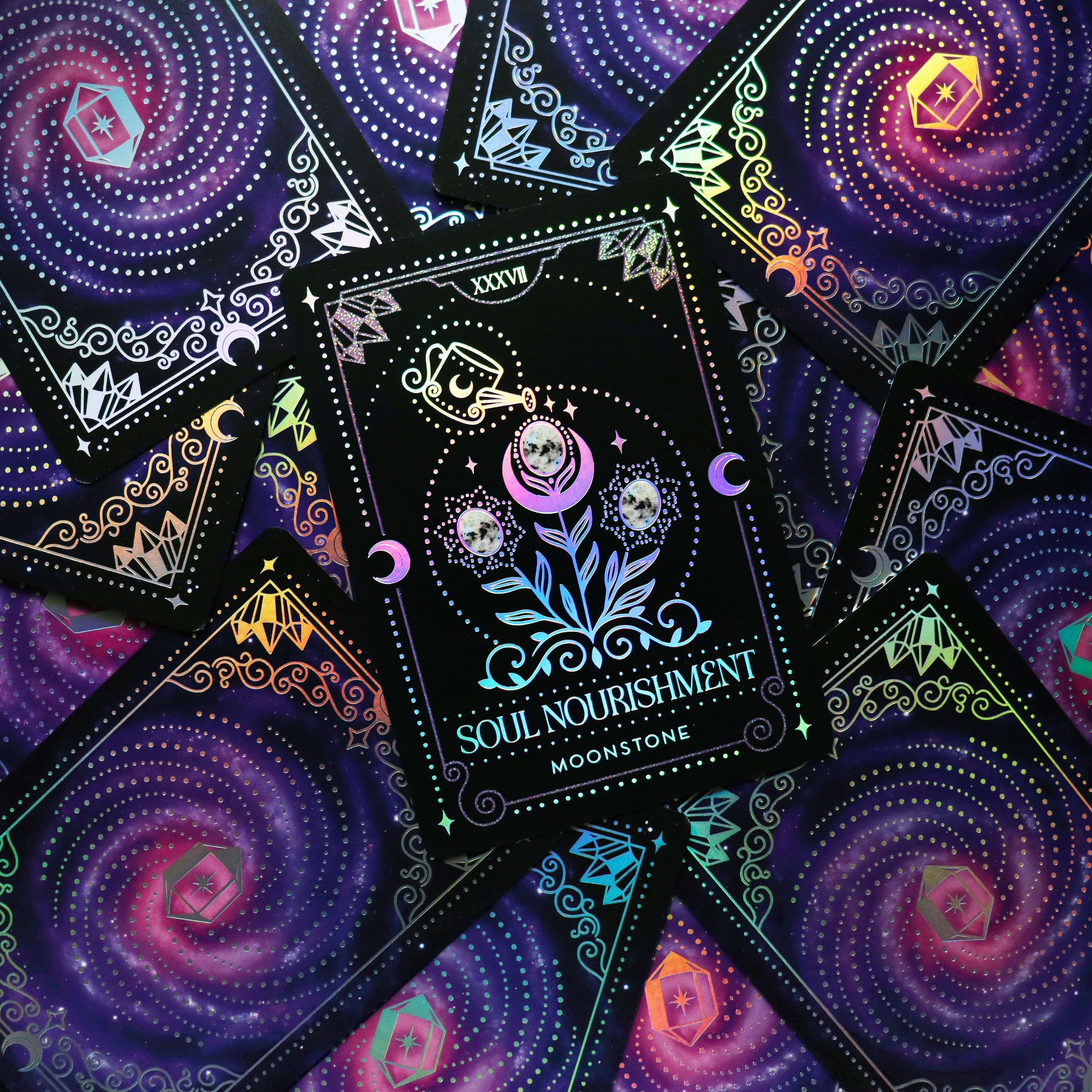 Crystal Portal Oracle Card Deck by Moonstruck Crystals, featuring colorful cards with mystical designs laid out on a wooden surface.