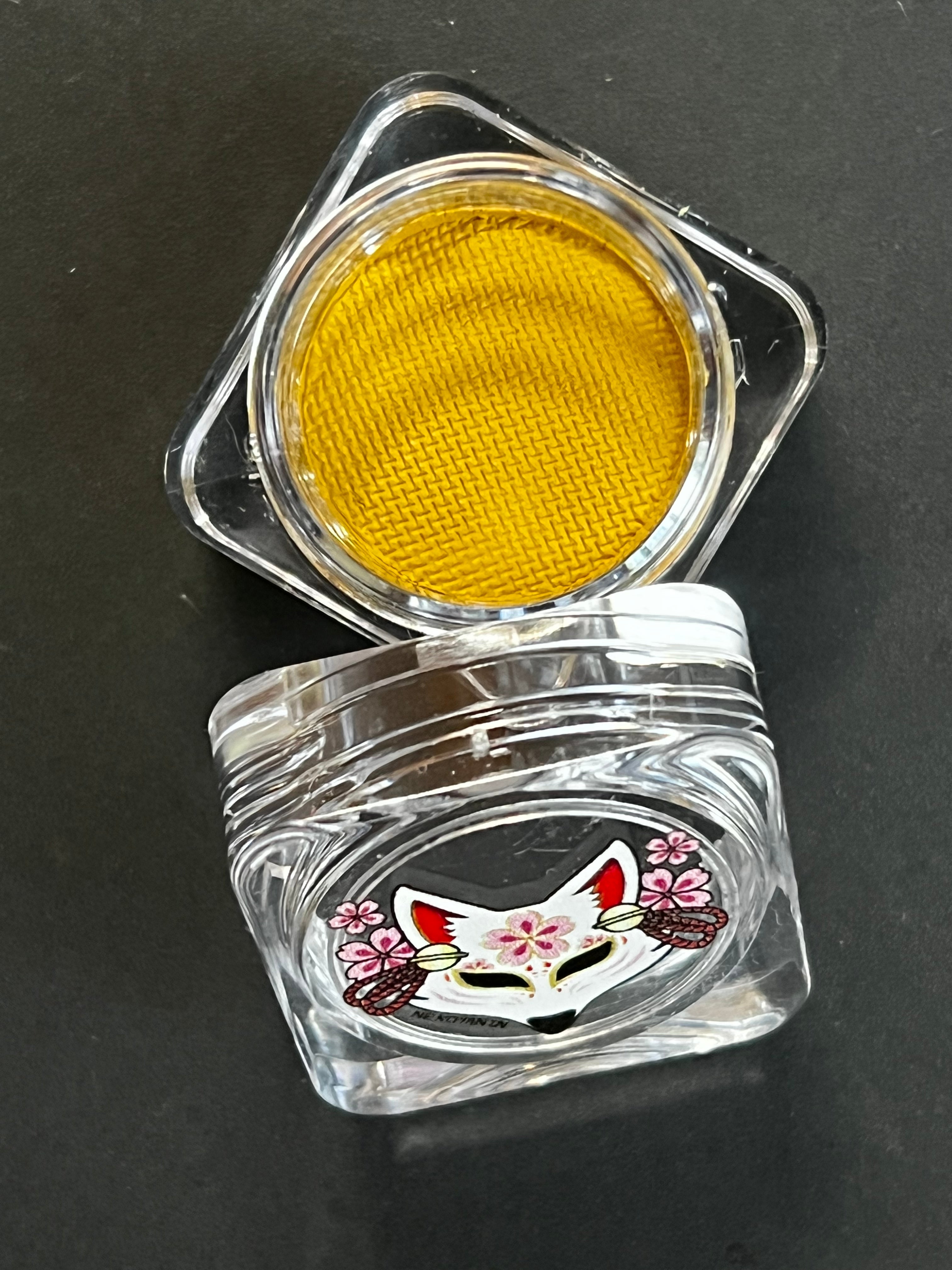 Yellow water-activated graphic eyeliner by Nekoyanin, featuring a vibrant mustard color and artistic design.
