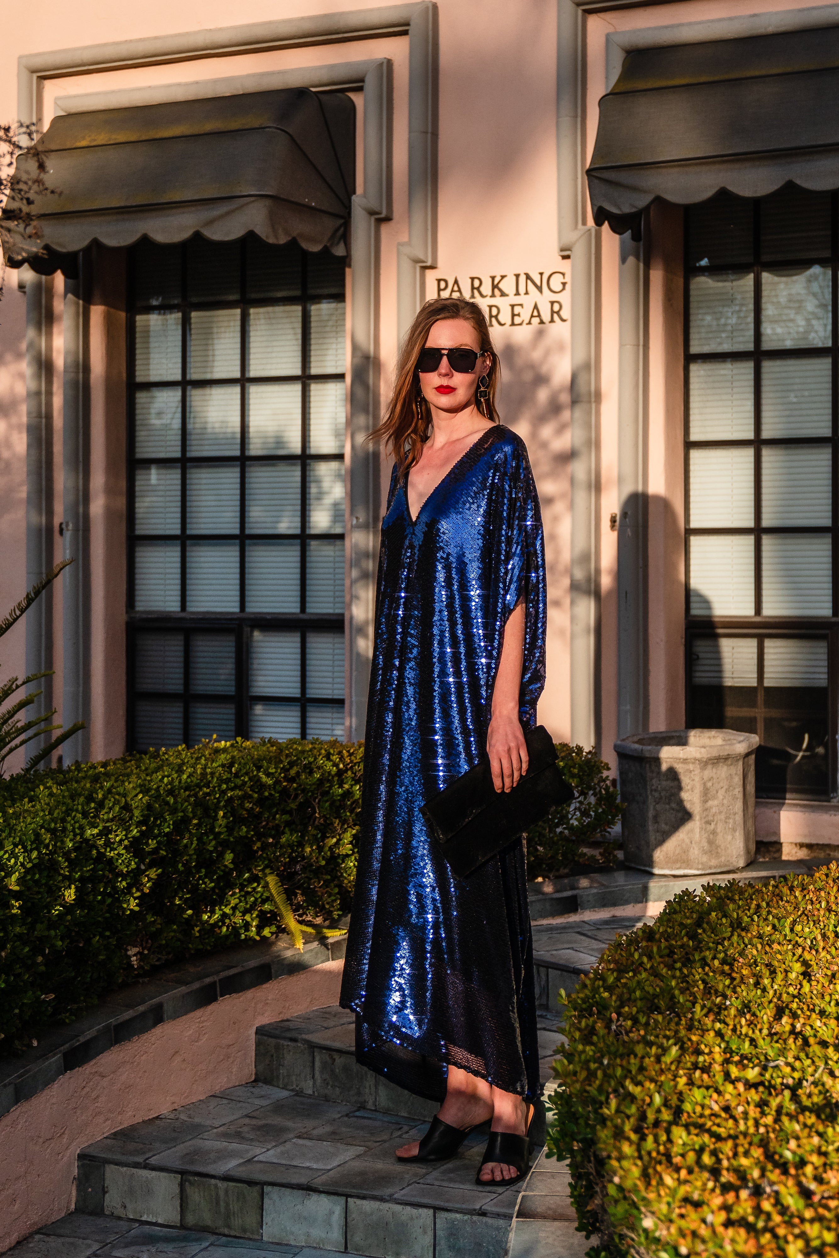 Night sapphire sequin caftan dress by Jennafer Grace featuring shimmering sequins and flowing fabric, displayed on a hanger.