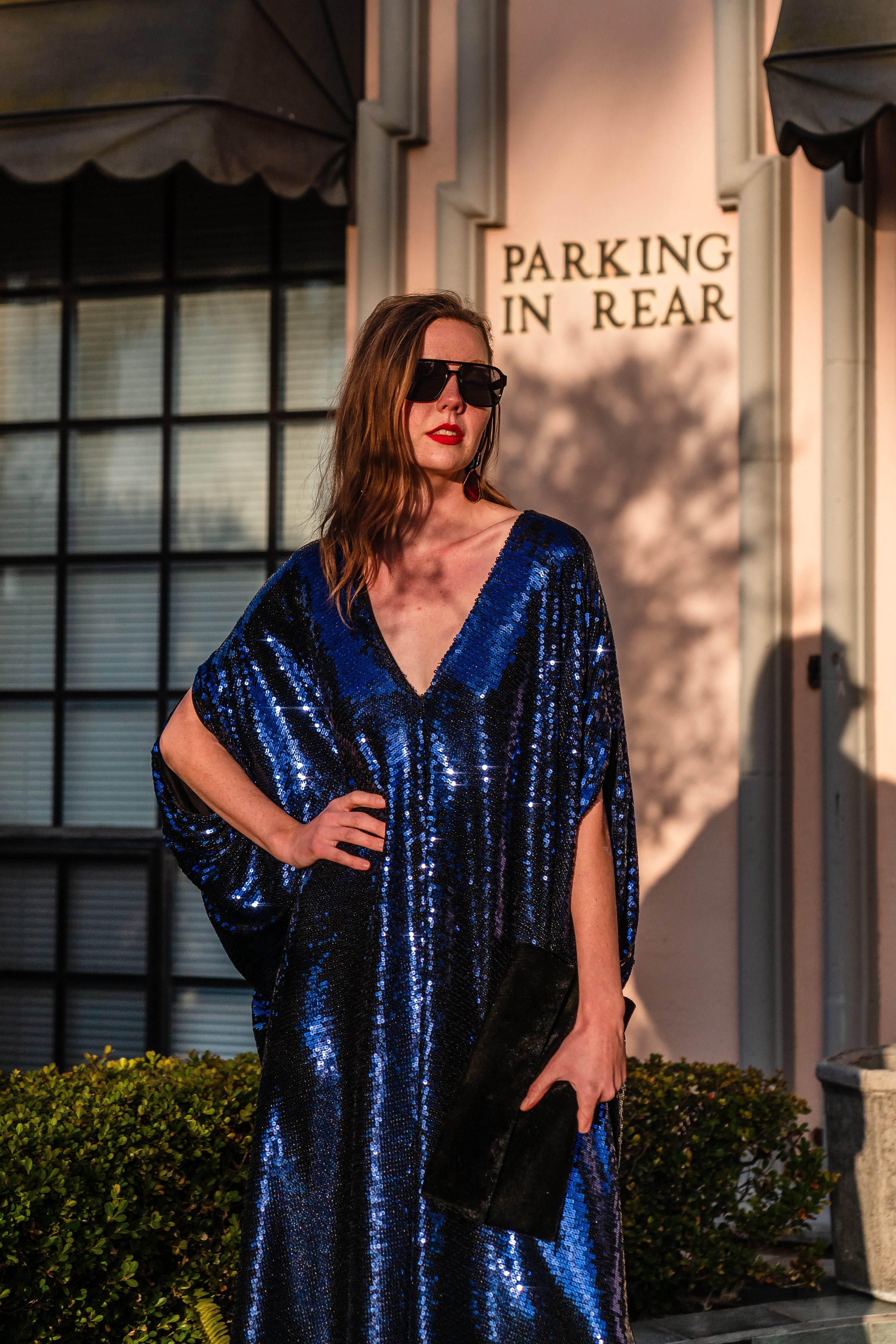 Night sapphire sequin caftan dress by Jennafer Grace featuring shimmering sequins and flowing fabric, displayed on a hanger.
