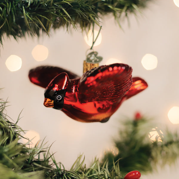 Old World Christmas Cardinal in Flight ornament featuring a vibrant red cardinal bird perched on a branch.