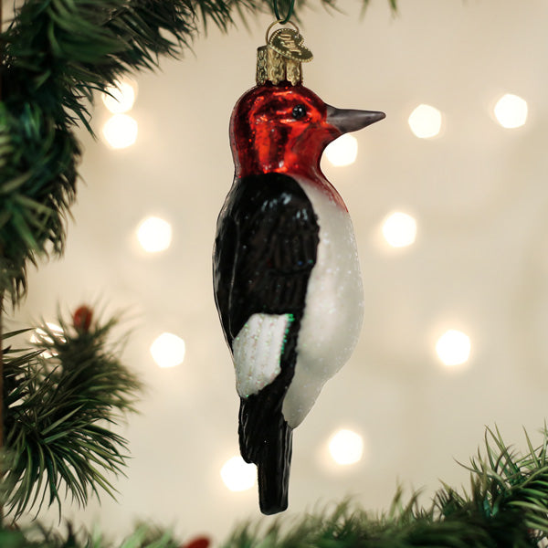 Red-headed Woodpecker ornament by Old World Christmas, detailed glass bird with vibrant red head and realistic features.