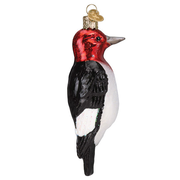 Red-headed Woodpecker ornament by Old World Christmas featuring a vibrant red head, detailed feathers, and a realistic bird design.