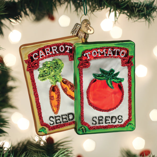 Old World Christmas garden seeds ornament, detailed glass decoration resembling garden seed packets with colorful designs.