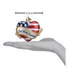 Old World Christmas God Bless America Heart ornament featuring a patriotic heart design on clear glass with red, white, and blue accents.