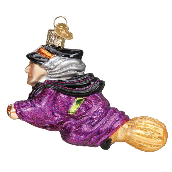 Old World Christmas witch on broomstick ornament, detailed holiday decoration featuring a festive witch figure on a broomstick.