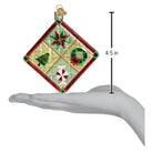 Old World Christmas Christmas quilt ornament with festive holiday patchwork and detailed stitching, hanging on a display.