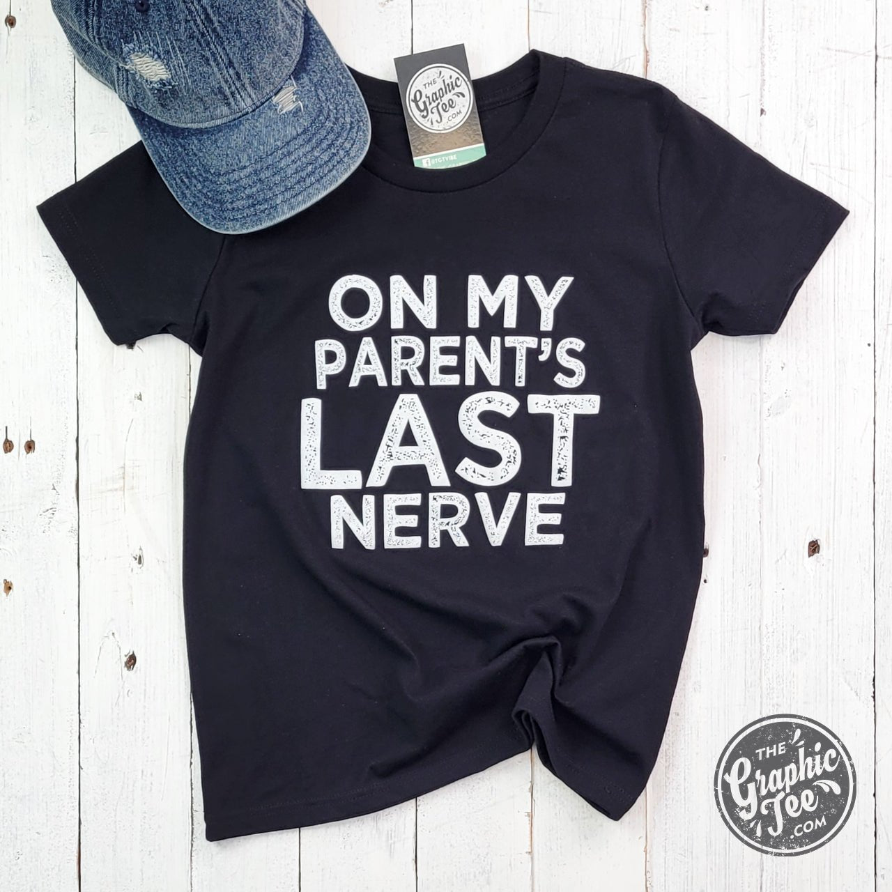 Youth SS graphic tee featuring humorous "On My Parent's Last Nerve" design by The Graphic Tee, displayed flat on a neutral background.