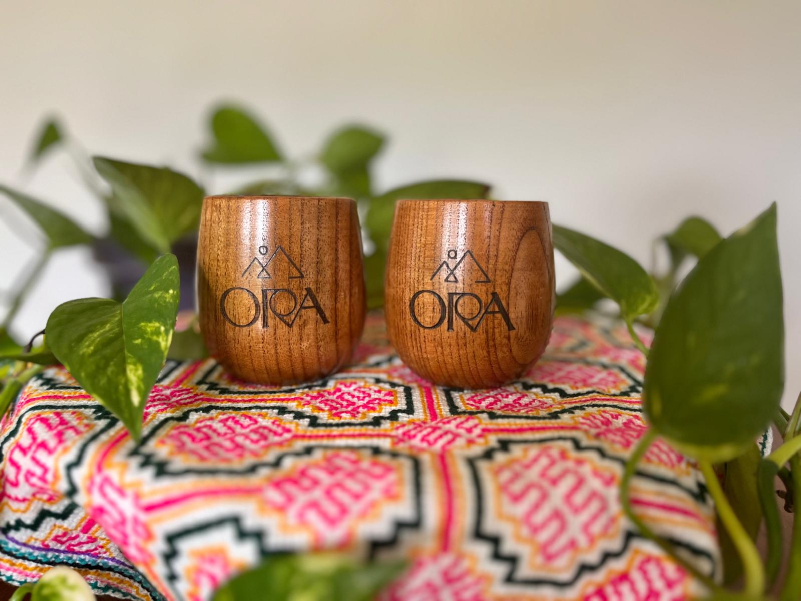 Ora Cacao Cups by Ora Cacao featuring smooth, dark chocolate cups filled with rich cacao filling on a rustic wooden surface.
