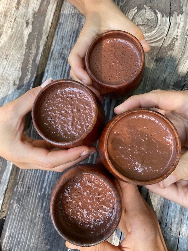 A close-up of Ora Cacao Cups, small handcrafted cacao cups filled with rich dark chocolate, showcasing their textured surface and artisanal design.