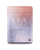 Pure 100% ceremonial cacao from Ora Cacao, connected Colombia, shown in a 1 lb package with rich cacao beans and natural setting.