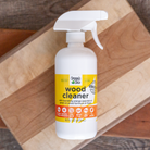 Organic Chix natural non-toxic wood cleaner in a spray bottle, showing wood surface with a clean, polished finish.