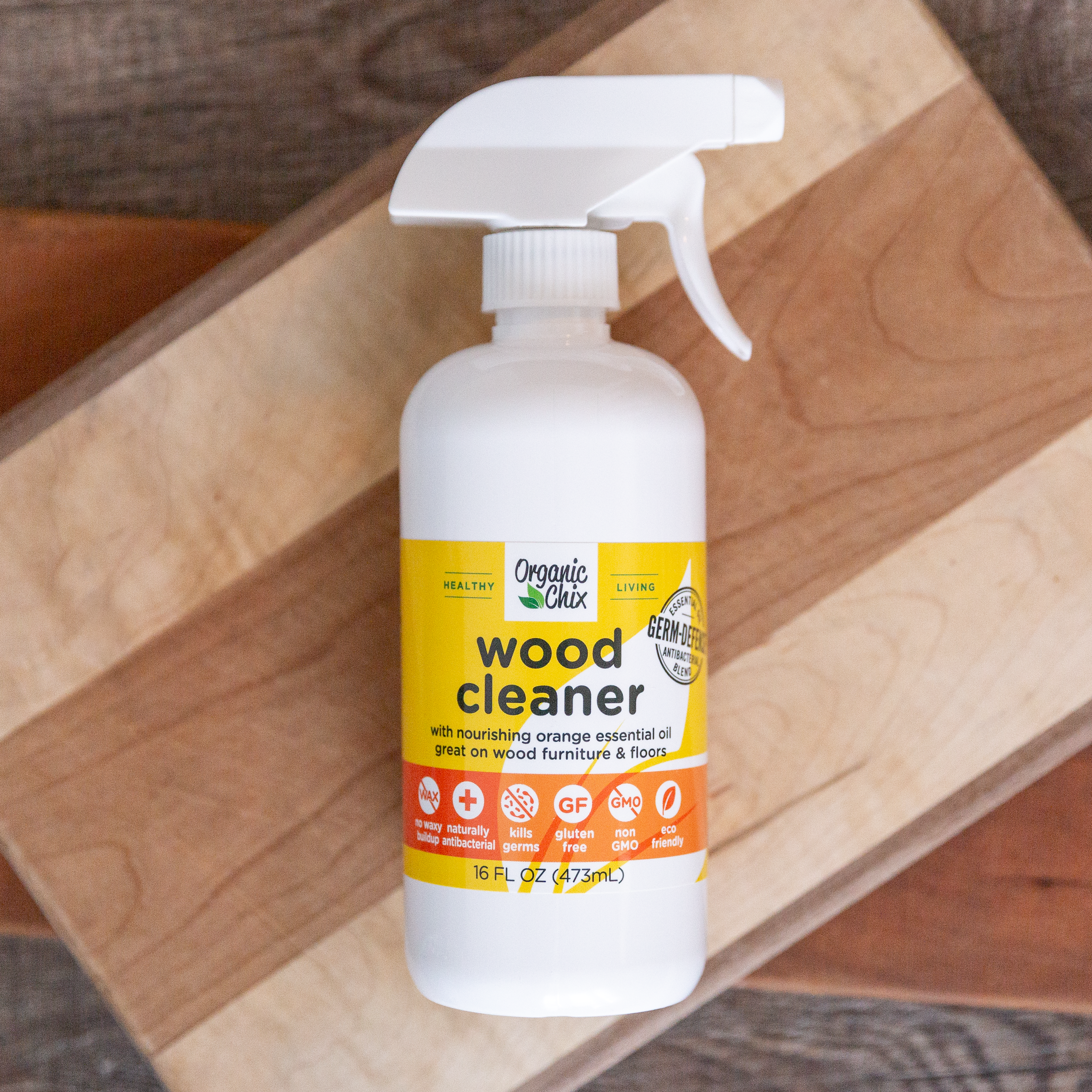 Organic Chix natural non-toxic wood cleaner in a spray bottle, showing wood surface with a clean, polished finish.