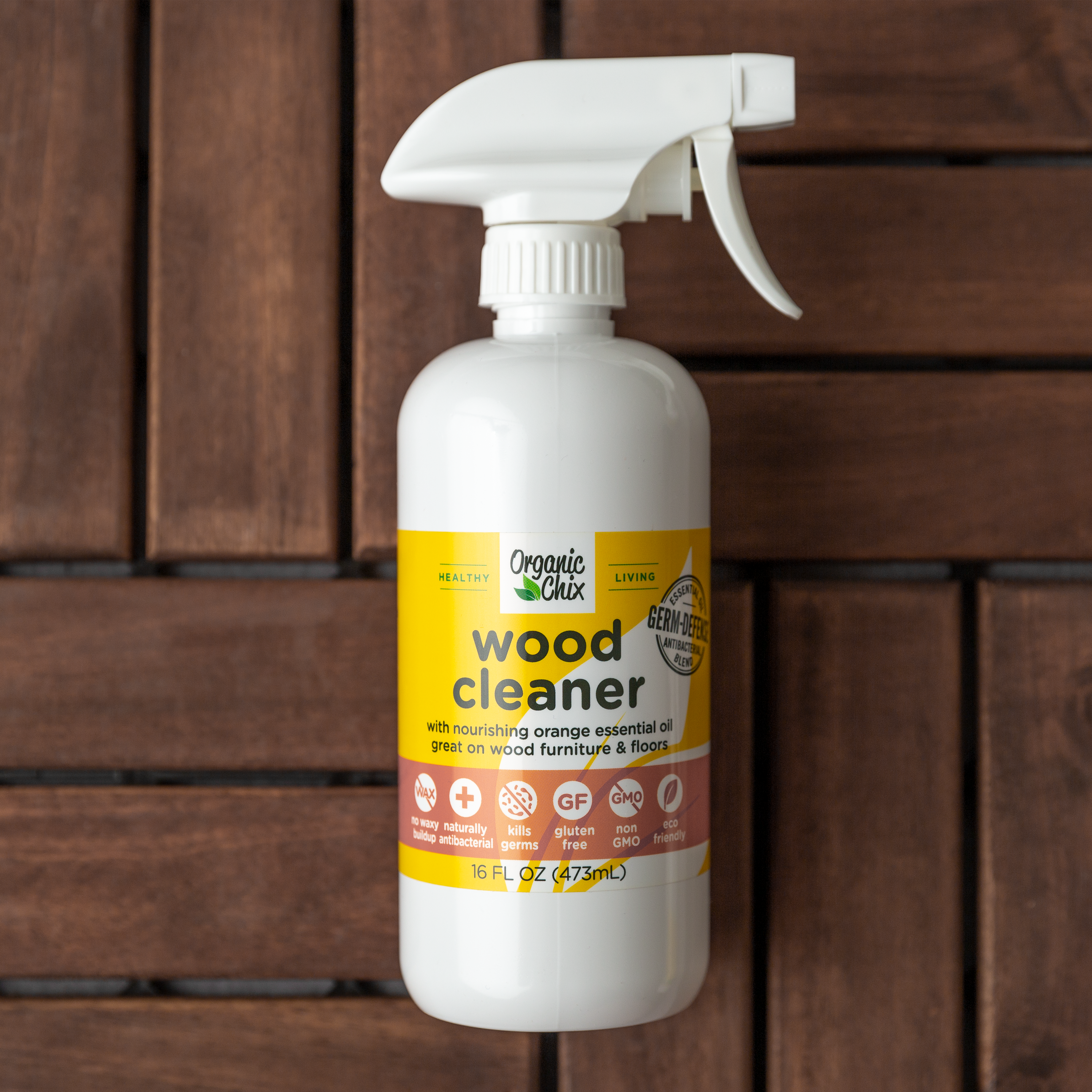 Organic Chix natural non-toxic wood cleaner in a spray bottle, showcasing a clean wooden surface with fresh, natural ingredients.