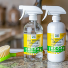 Organic Chix Natural Non-Toxic Stain Remover for healthy laundry, showing a clear spray bottle with label and stains being treated.