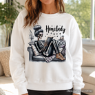 Homebody Reading Skeleton Sweatshirt by OrnamentallyYou, cozy and funny self-care sweater for introvert women, in ash color.