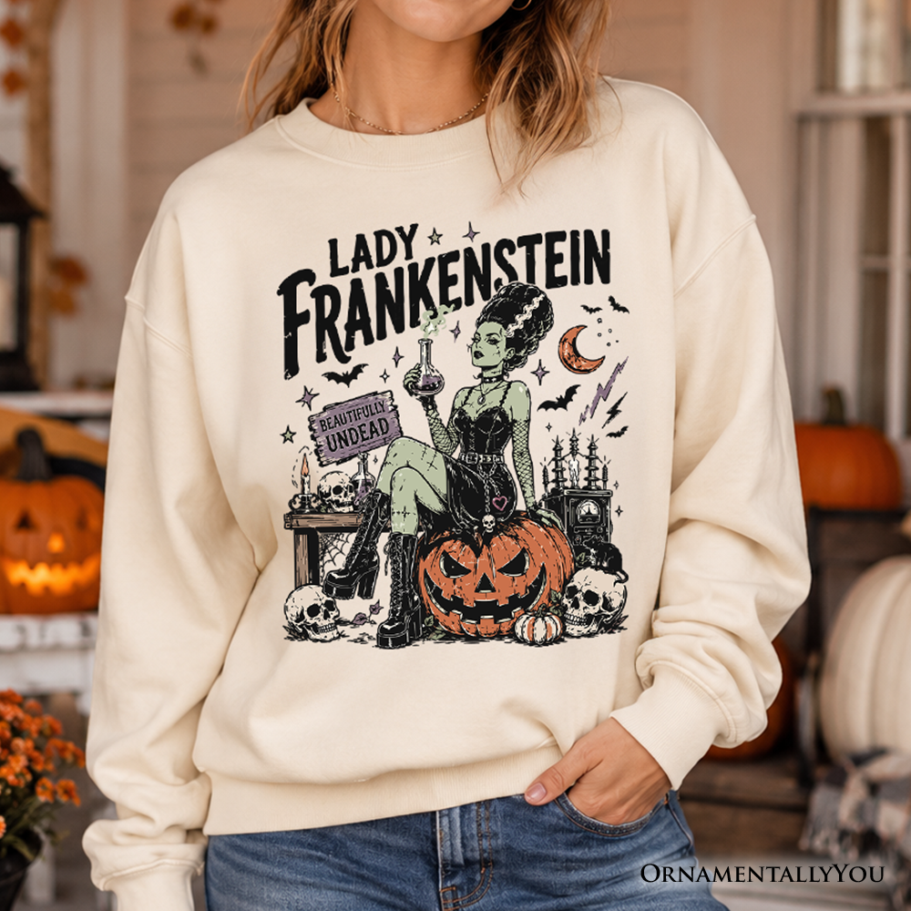 Lady Frankenstein sweatshirt by OrnamentallyYou featuring vintage gothic design with undead Halloween theme, displayed on a hanger.