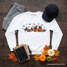 Black sweatshirt featuring skeleton cats and pumpkins with spooky Halloween design, from OrnamentallyYou.