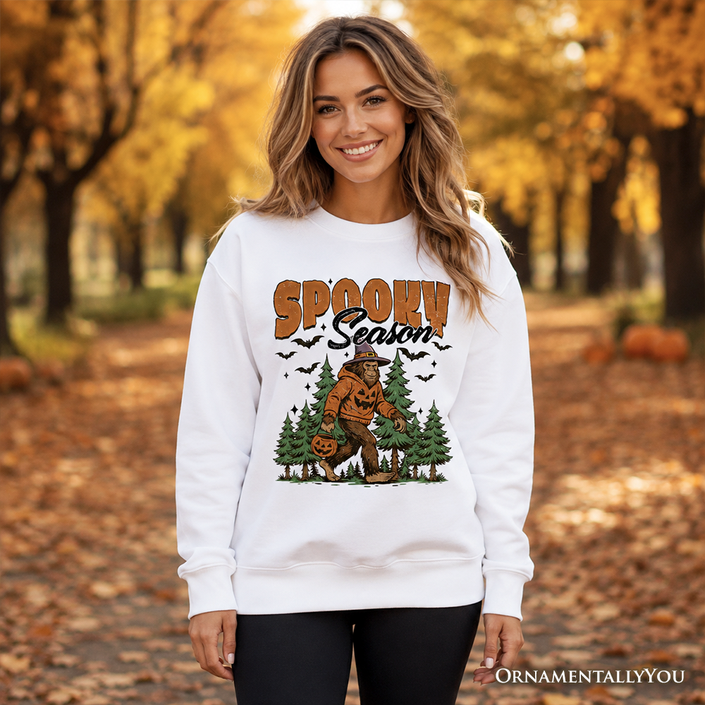 Spooky Season Bigfoot Halloween sweatshirt featuring a Sasquatch and pumpkin design, in a cozy sweater style by OrnamentallyYou.