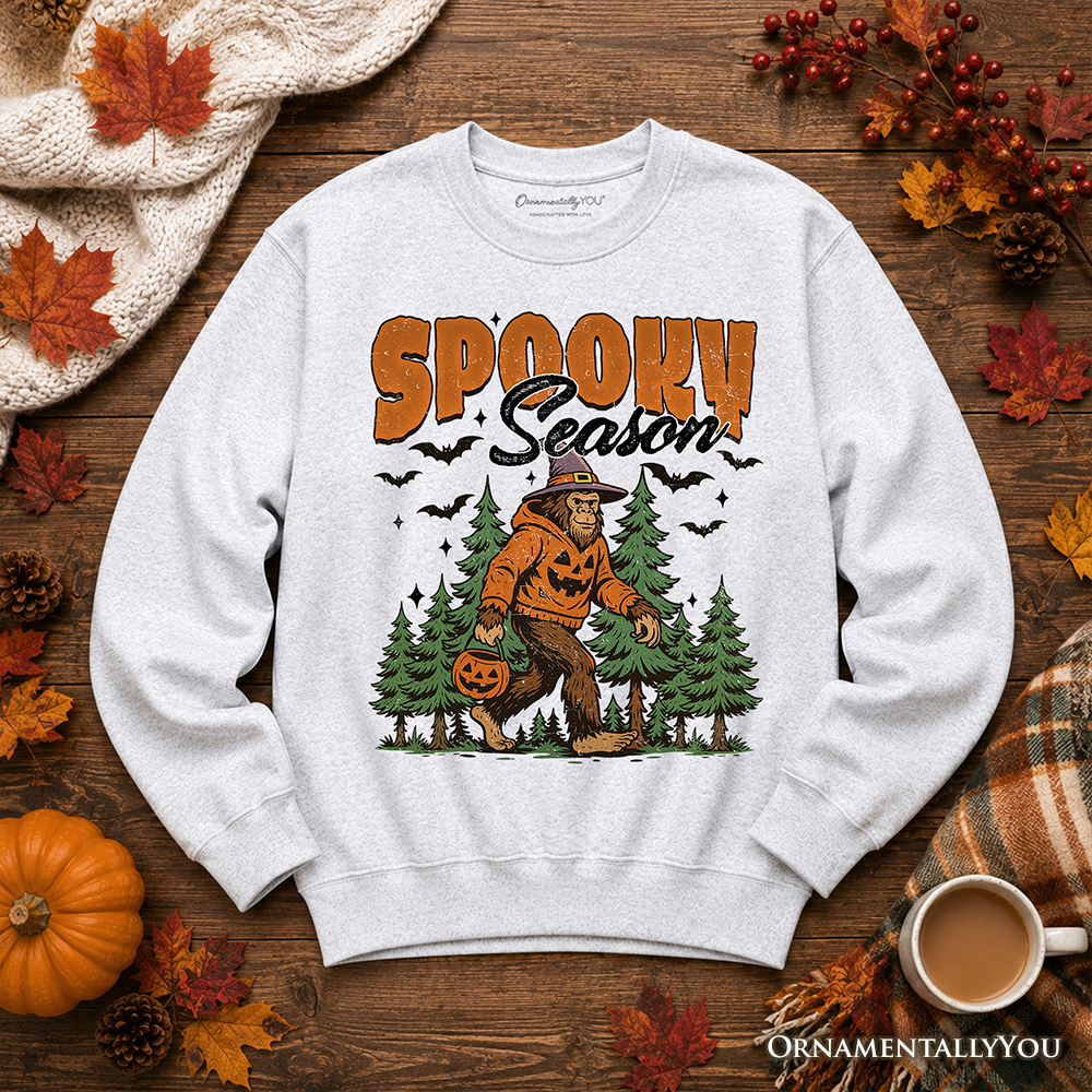 Spooky Season Bigfoot Halloween sweatshirt by OrnamentallyYou featuring Sasquatch and pumpkin design on a cozy sweater.