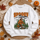 Orange Halloween Bigfoot sweatshirt featuring spooky Sasquatch and pumpkin design, by OrnamentallyYou.