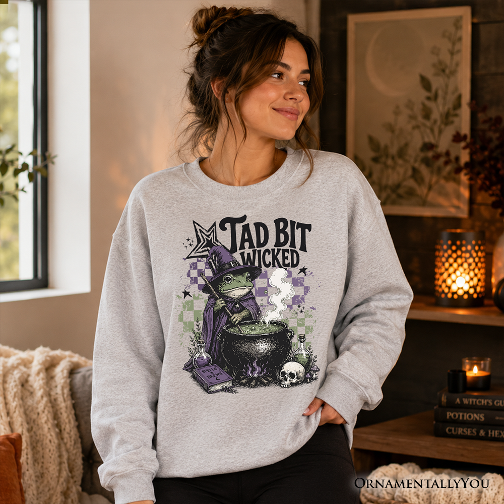 Ash gray Tad Bit Wicked Frog Witch sweatshirt featuring a spooky Halloween cauldron design by OrnamentallyYou.