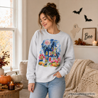 Colorful watercolor haunted house sweatshirt featuring ghosts and pumpkins, perfect for Halloween, by OrnamentallyYou.