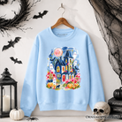 Colorful watercolor haunted house sweatshirt with ghost and pumpkin Halloween design by OrnamentallyYou, featuring vibrant spooky illustrations.