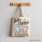 Beige Salty Moms Beach Club canvas tote bag with retro summer design, ideal for ocean-loving mothers and beach outings.