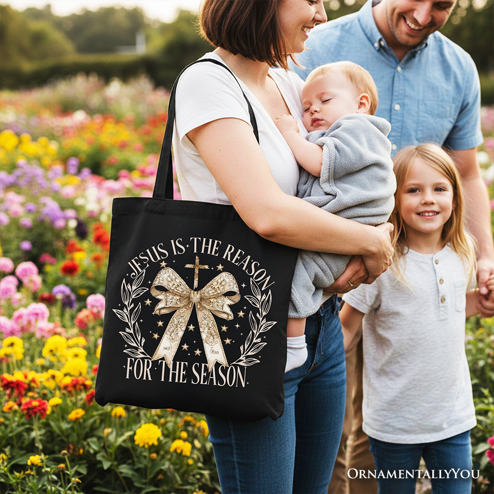 Black tote bag by OrnamentallyYou featuring a Jesus is the Reason Christmas design, gold bow, and cross, perfect for faithful women.