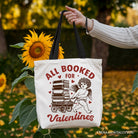 White canvas tote bag featuring a vintage "All Booked For Valentines" Cupid design, perfect for bookworm gift lovers.
