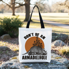 White canvas tote bag featuring a humorous armadillo design, perfect for western animal gift shopping or casual use.