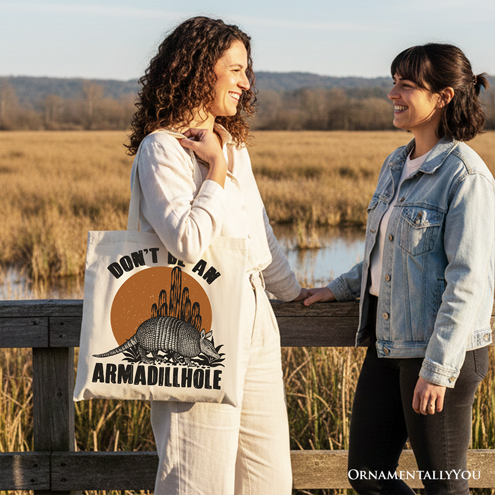 White canvas tote bag featuring humorous "Don’t Be An Armadillhole" armadillo design, perfect for casual shopping or gifting.