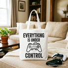 White tote bag with "Everything Is Under Control" and a video game controller design, perfect for gamers and shoppers.